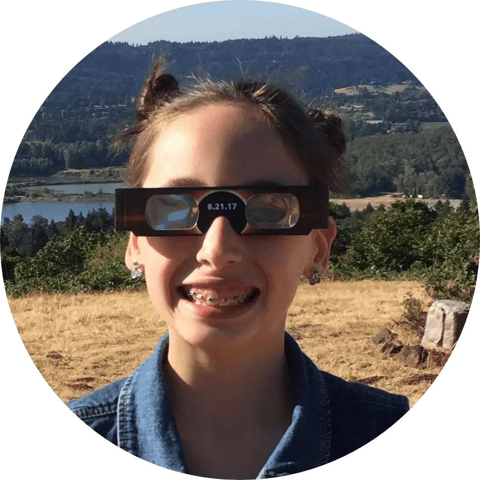 girl with braces with a mountain background.